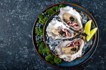 Fresh oysters with black sturgeon caviar and octopuses in a luxurious serving in blue ceramic...