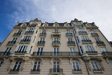 Fototapeta na wymiar The facade of traditional French house with typical balconies and windows. Paris.