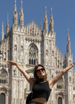A girl standing in front of Milan Cathedral. Awe-inspiring experience of being in the presence of the iconic cathedral, evoking a sense of wonder and admiration.
