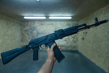 Assault rifle ak 74m in male hands in a shooting range.