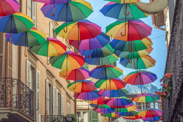 Rainbow umbrellas on blue sky background. Many colorful umbrellas, street decoration for festivals. Concept diversity