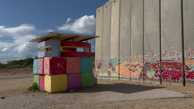 At the border wall between Israel and the Gaza Strip, the Israeli side is decorated with murals and messages of peace. A colorful observation hut is adjacent to the wall.