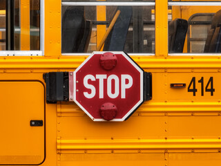 View of the drivers side of a yellow school bus in a parking lot.	