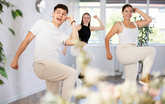 Group of young women and young guy rehearsing jazz funk dance in dance studio