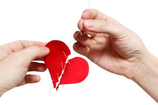 Hands repairing a broken red heart using needle and thread, cut out