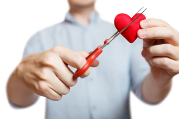Male hands cutting a plush red love heart with scissors, cut out