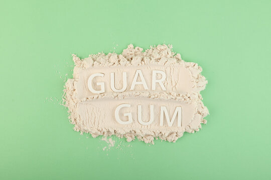 Pile of Guar gum powder or guaran. Inscription GUAR GUM.  Food additive E412. Fat Replacer, Dough Improver, Improve Moisture, Structure, Texture