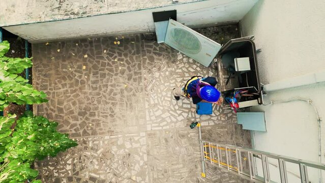 Drone shot of african american wireman putting together manometers before starting work. Professional worker checking refrigerant leaks leading to reduced cooling efficiency
