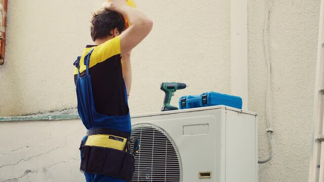 Skillful wireman arriving on location to fix system electrical issues caused by faulty wiring or damaged capacitor requiring professional intervention to diagnose and recondition