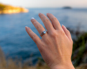 Hand with a wedding ring of the bride on the beach