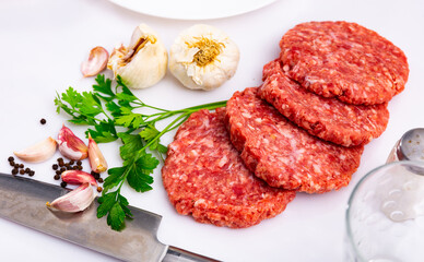 Cooking ingredients, raw burger cutlets on wooden board