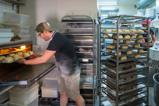 Baker of bakery in workshop workshop of artisan bakery preparing croissant and neapolitan for baking