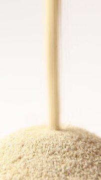 Sand pours like an hourglass. The concept of leaking sand as time is irrevocable