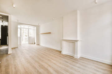 an empty living room with wood flooring and white walls, there is a fireplace in the center of the room
