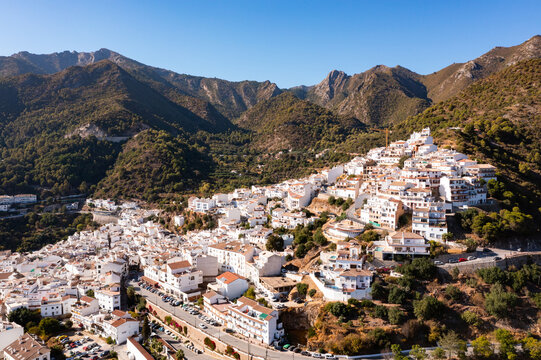 Ojen, small Spanish old town village of white Andalucian houses with green nature around on a sunny day