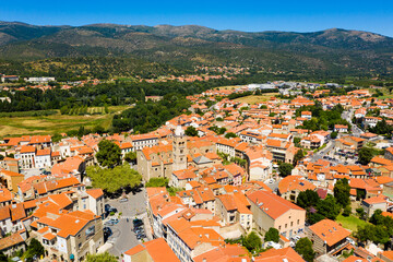 Fototapeta na wymiar Aerial view of residential areas of Prades town with similar brownish roofs in green valley of French Pyrenees on summer day, Occitanie
