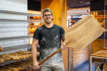 Portrait of baker of bakery in workshop workshop of artisan bakery with shovel