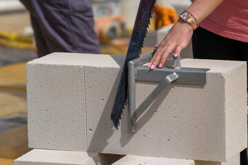 Female Architecture student learns how to cut aerated concrete.