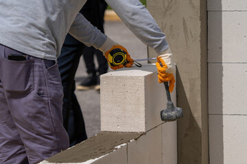 The bricklayer is working. Building a wall of aerated concrete. Gasbeton wall