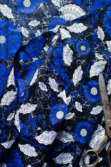 top view of blue and white floral ankara fabric, flatlay of nigerian wax cloth, rumpled blue and white ankara floral material