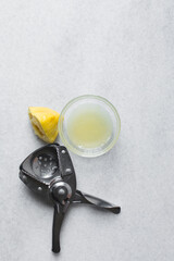 Vintage citrus squeezer, antique lemon and lime juicer, lemon and lemon juice on a marble table