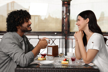 International dating. Happy couple spending time together in restaurant