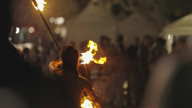 A woman performing a fire show outdoors