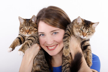 Young woman with domestic cats against white background.