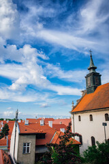 Petrovaradin is historic town on right bank of Danube in Serbia, part of Novi Sad.  Top view of the tiled orange roofs with white chimneys and magic cloudy sky