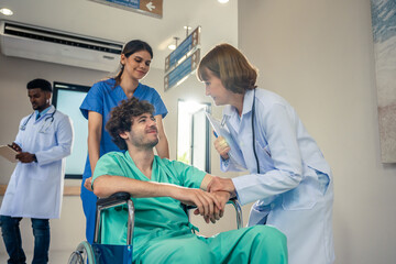 Obraz premium Caucasian doctor support patient sit on wheelchair in hospital hallway. 