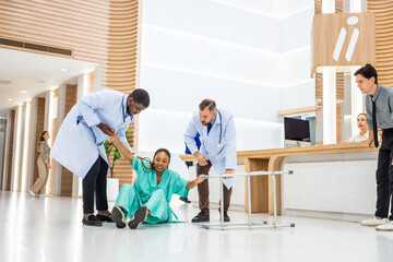 Group of people help female patient falling on the ground in hospital. 