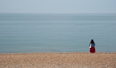 Person relaxing on a pebble beach. Summer holidays people leisure time