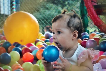 Fototapeta na wymiar Bebé curiosa en piscina de pelotas
