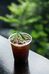 ice coffee with a cannabis leaf on the table