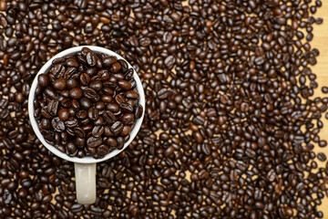 Whole grains of coffee beans are placed in a cup in the upper corner before grinding to drink.