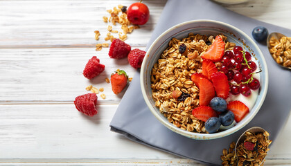Tasty granola with fresh berries on white wooden background