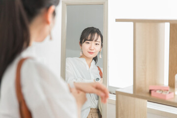 Fototapeta premium アクセサリーショップ・雑貨店で腕時計を選ぶ鏡越しの女性客 