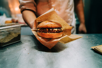 Chef holding hamburger with cheese in a food truck - obrazy, fototapety, plakaty