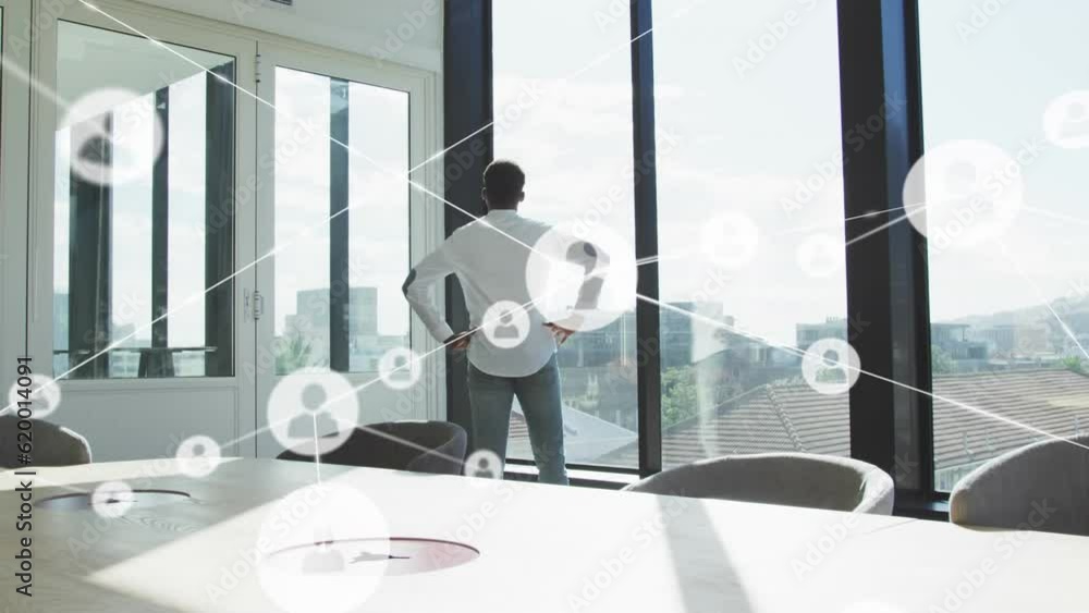 Poster animation of network of profile icons against rear view of man looking out of window at office