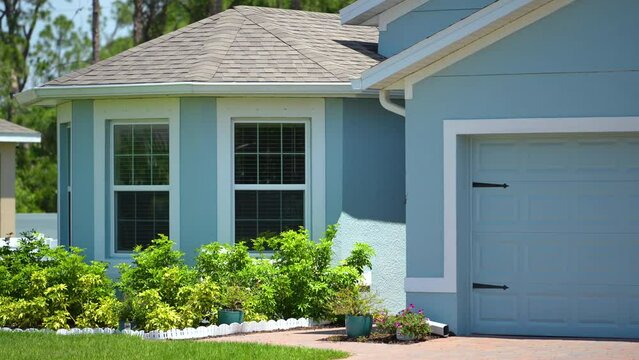 Front view of generic private house in southern Florida. Single family home with double car garage door and wide driveway