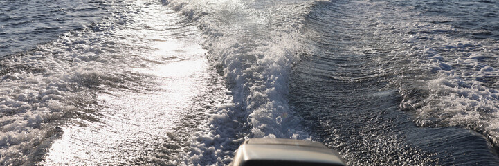 Outboard motor wake from cruising powerboat on sea