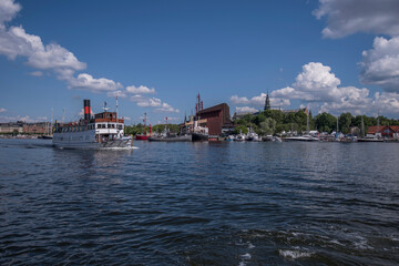 Naklejka premium Old steam boat leaving for the archipelago, background maritime museums, a sunny summer day in Stockholm