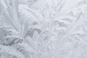 Frozen ice patterns on single pane glass window in winter