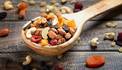 Nuts and dried fruit mix, healthy and wholesome food. Vintage wooden background, selective focus