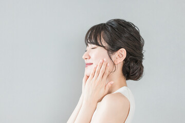 スキンケアをする美肌のアジア人女性の横顔（化粧水・保湿・美白）
