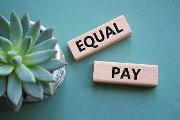 Equal Pay symbol. Wooden blocks with words Equal Pay. Beautiful grey green background with...