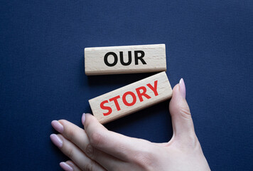 Our story symbol. Wooden blocks with words Our story Beautiful deep blue background. Businessman hand. Business and Our story concept. Copy space.