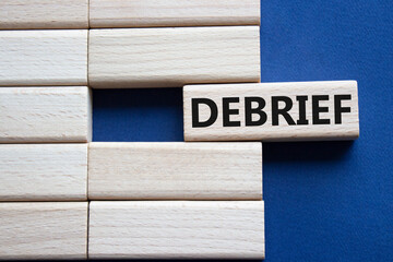 Debrief symbol. Concept word Debrief on wooden blocks. Beautiful deep blue background. Business and...