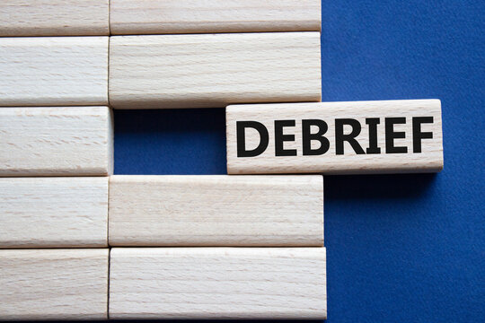 Debrief symbol. Concept word Debrief on wooden blocks. Beautiful deep blue background. Business and Debrief concept. Copy space.