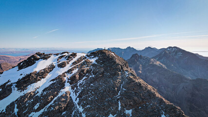 Hiker conquering snowy Cuillin Ridge, Isle of Skye, Scotland.